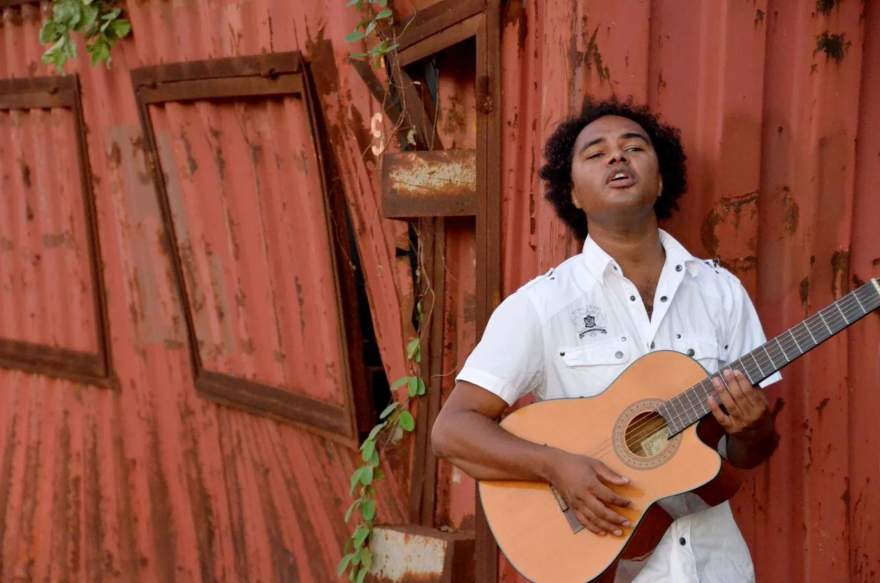 Dino Miranda. With acoustic guitar, red wall