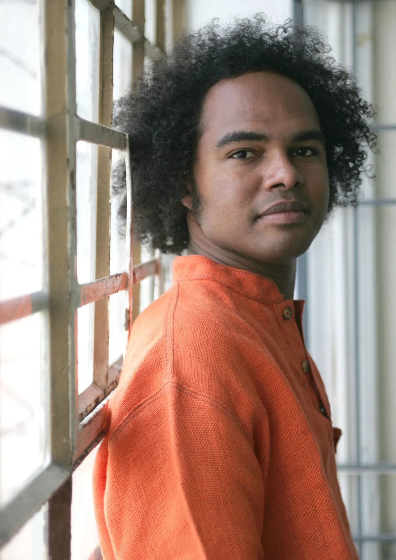 Dino Miranda by a window in an orange shirt